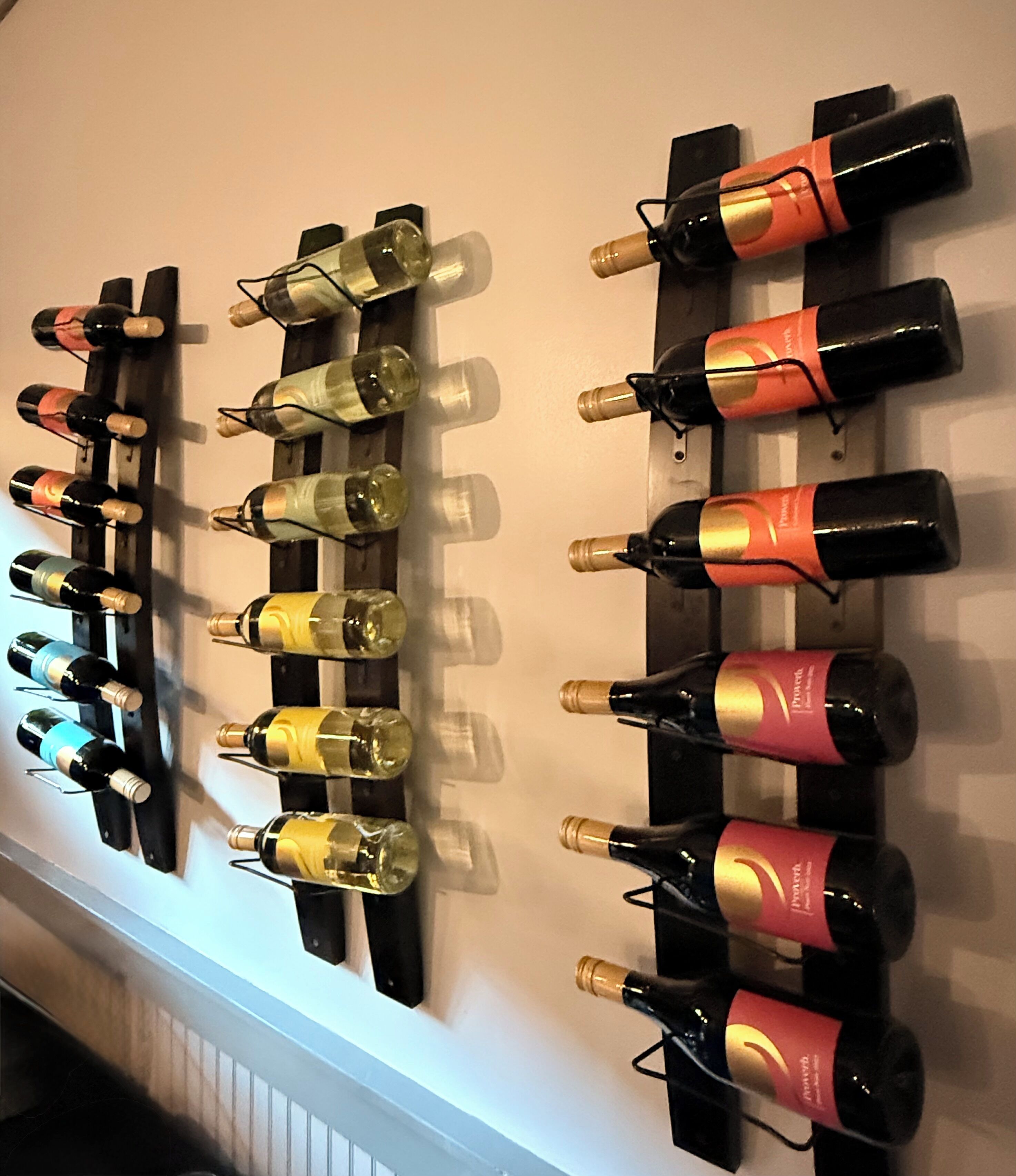 Uma adega suspensa na parede com várias garrafas de vinho.