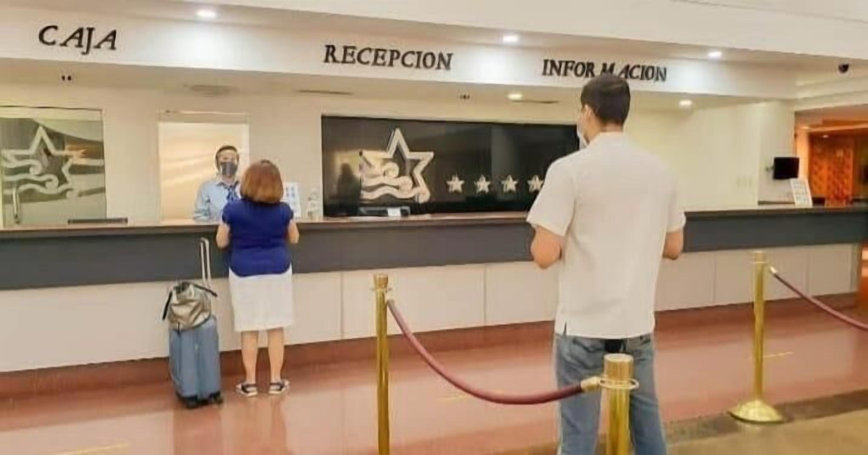 Una zona d'entrada amb un taulell indicat amb 'CAJA' i 'RECEPCIÓ'.