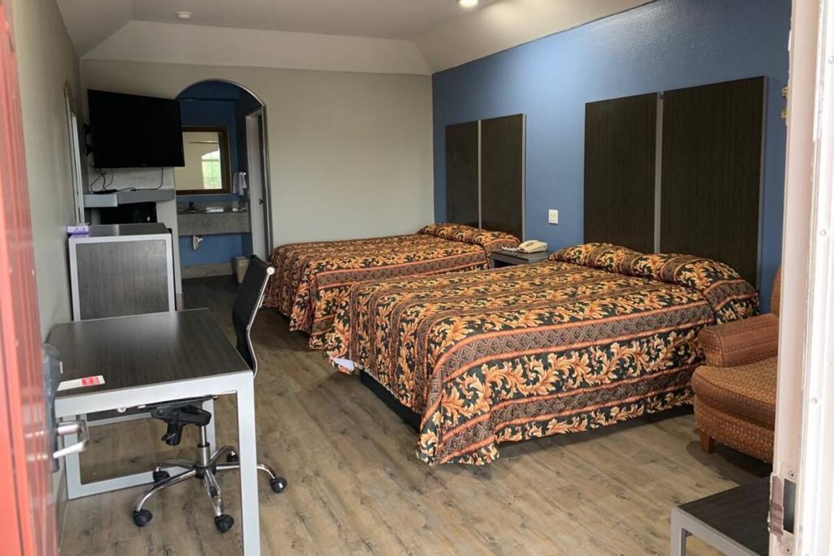 A room with two beds, a desk, and a TV.