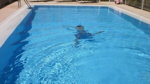 Una piscina con agua cristalina y una persona nadando.