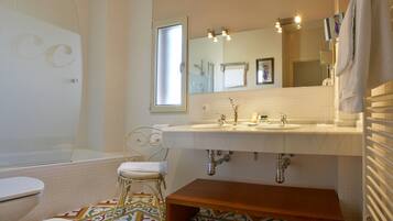 A bathroom with a white sink, a mirror, a toilet, and a shower.