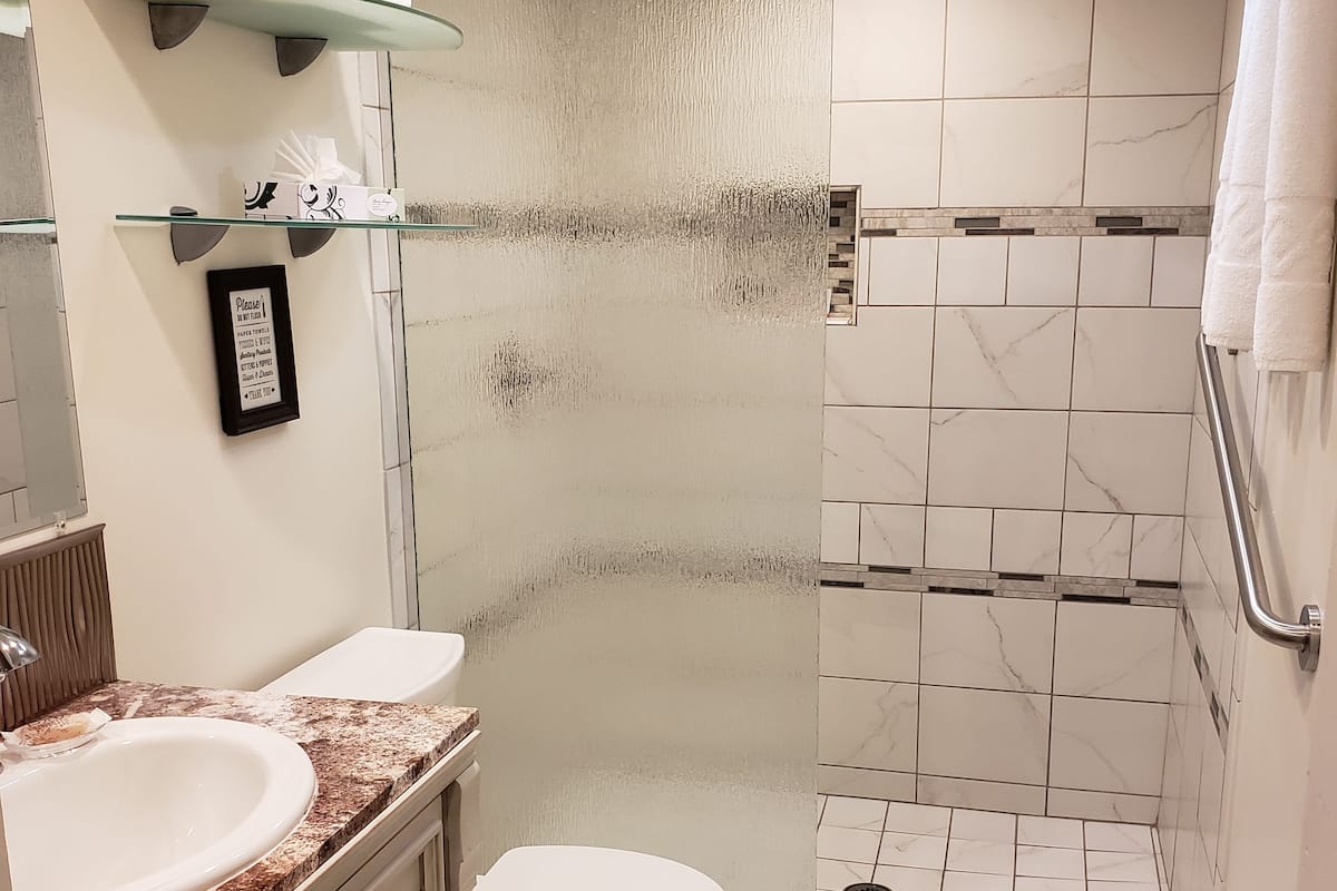 room, 2 queen beds | bathroom | rainfall showerhead, designer toiletries, hair dryer, towels