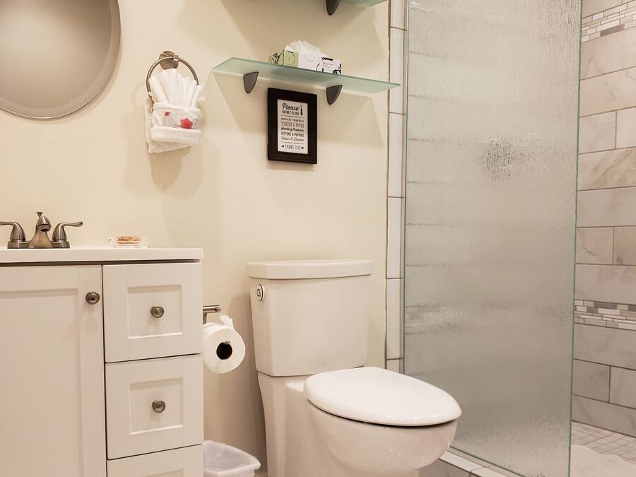 Ein Badezimmer mit Toilette, Waschbecken und einer Duschkabine aus Glas.