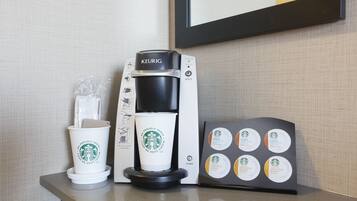 A Keurig coffee machine with a coffee cup and a coffee pod holder on a counter.