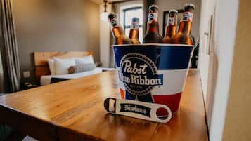 A bucket of Pabst Blue Ribbon beer on a wooden table in a hotel room.