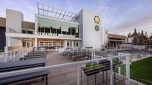 A modern building with the sign "MILWAUKEE BREWING CO" and outdoor seating area with tables and chairs. - The Brewhouse Inn & Suites (Milwaukee)