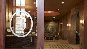 A lobby with a reception desk, a large wall mural, and a seating area. - The Brewhouse Inn & Suites (Milwaukee)