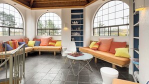 A cozy reading nook with a cushioned bench, a small table, and a bookshelf.