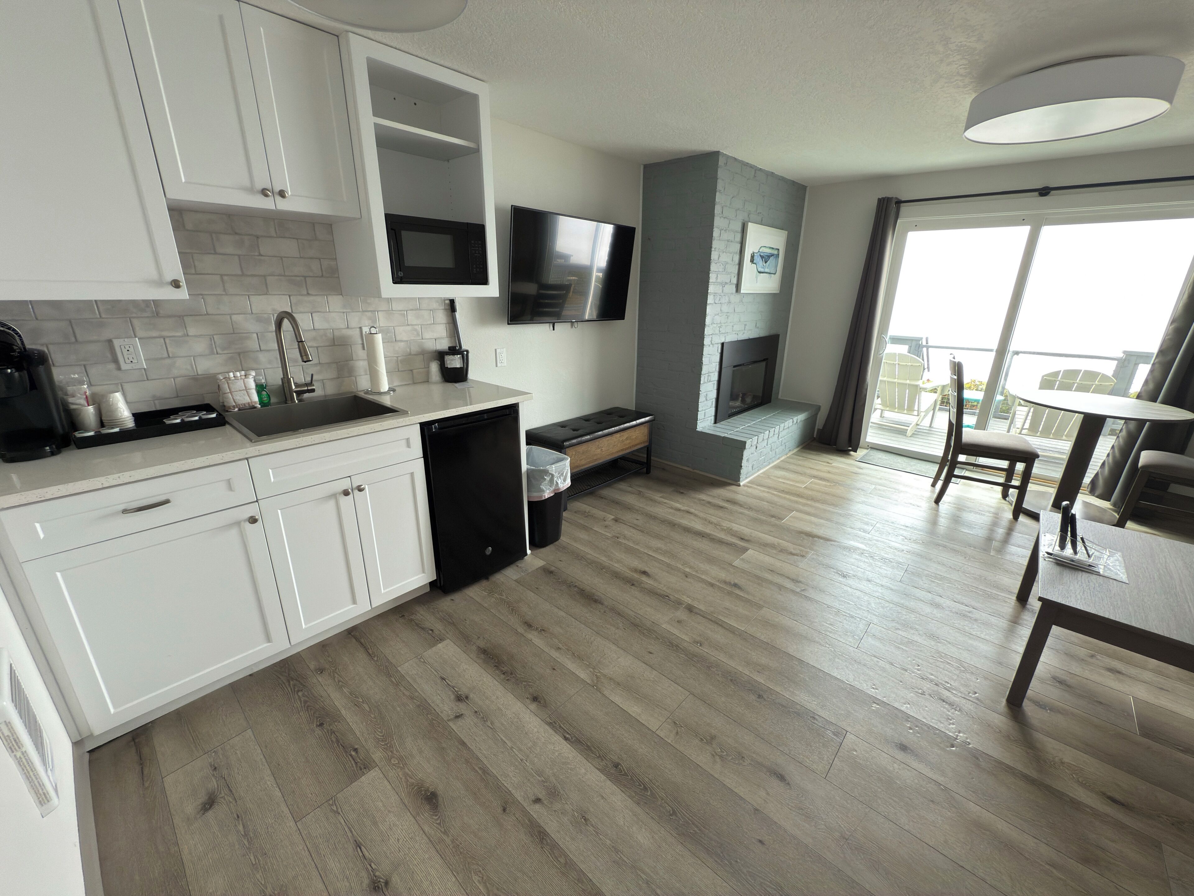 A modern kitchen with white cabinets, a built-in microwave, and a black dishwasher.