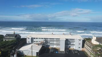 Edifício costeiro com estacionamento e vista para o oceano.