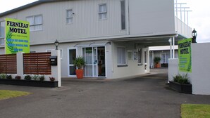 A two-story motel with a covered entrance and a signboard advertising amenities like an outdoor pool and WiFi. - Fernleaf Motel (Rotorua)