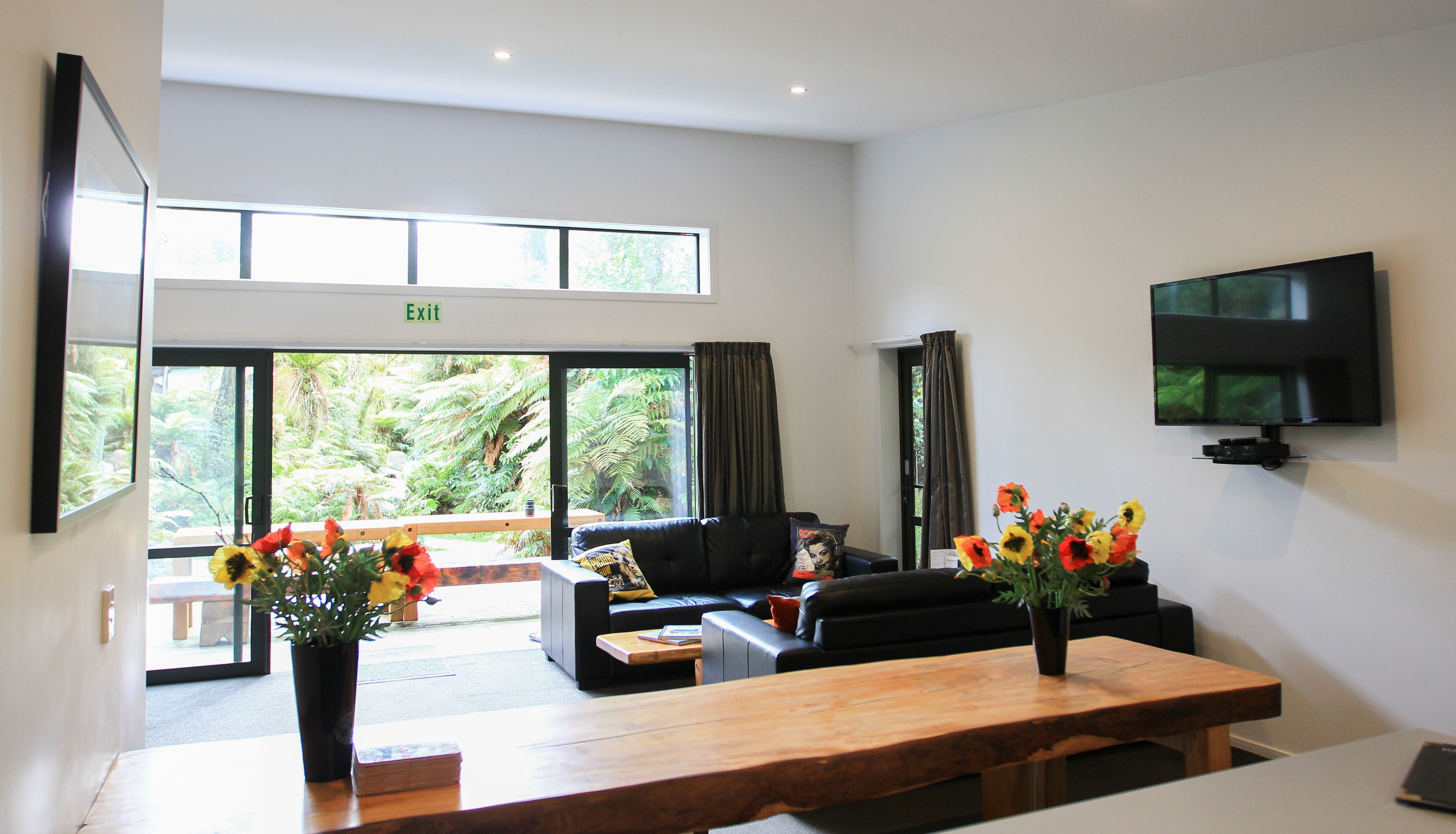A modern living room with a sofa, a coffee table, and a TV mounted on the wall.