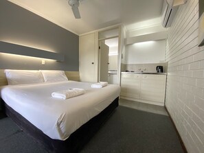 A hotel room with a bed, a small kitchenette, and a bathroom. - Mahogany Motel (Warrnambool)