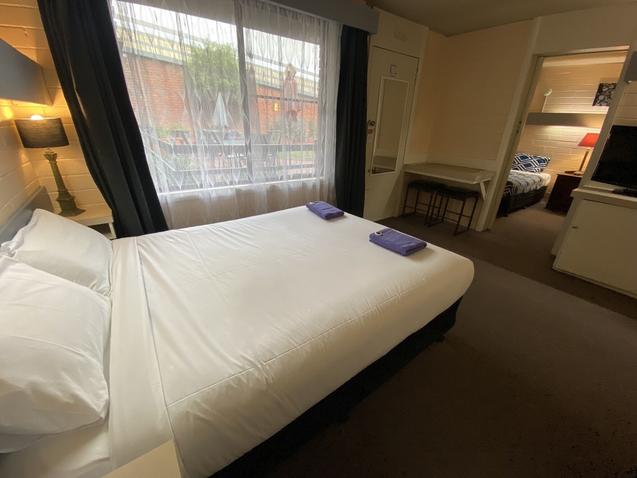 Hotelkamer met een groot bed, een bureau, een stoel, een televisie en uitzicht.