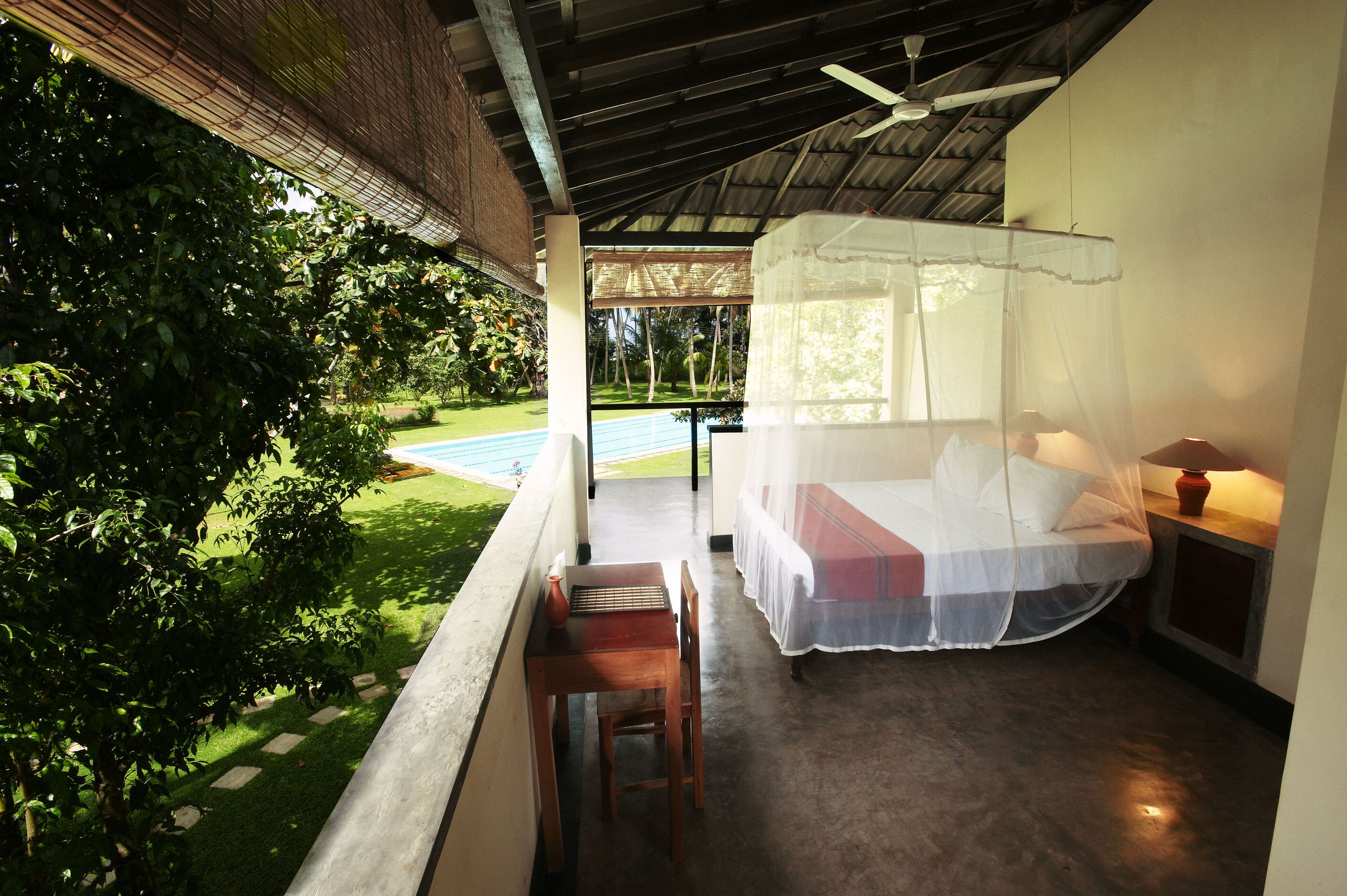 A balcony with a bed, a table, and a chair.