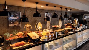 A buffet with various food items, including bread, pastries, and a hot beverage station. - J4 Hotels Legian (Kuta)