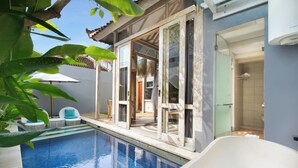 A pool area with a glass-enclosed patio, a shower room, and a seating area with chairs and a table. - 18 Suite Villa Kuta (Kuta)
