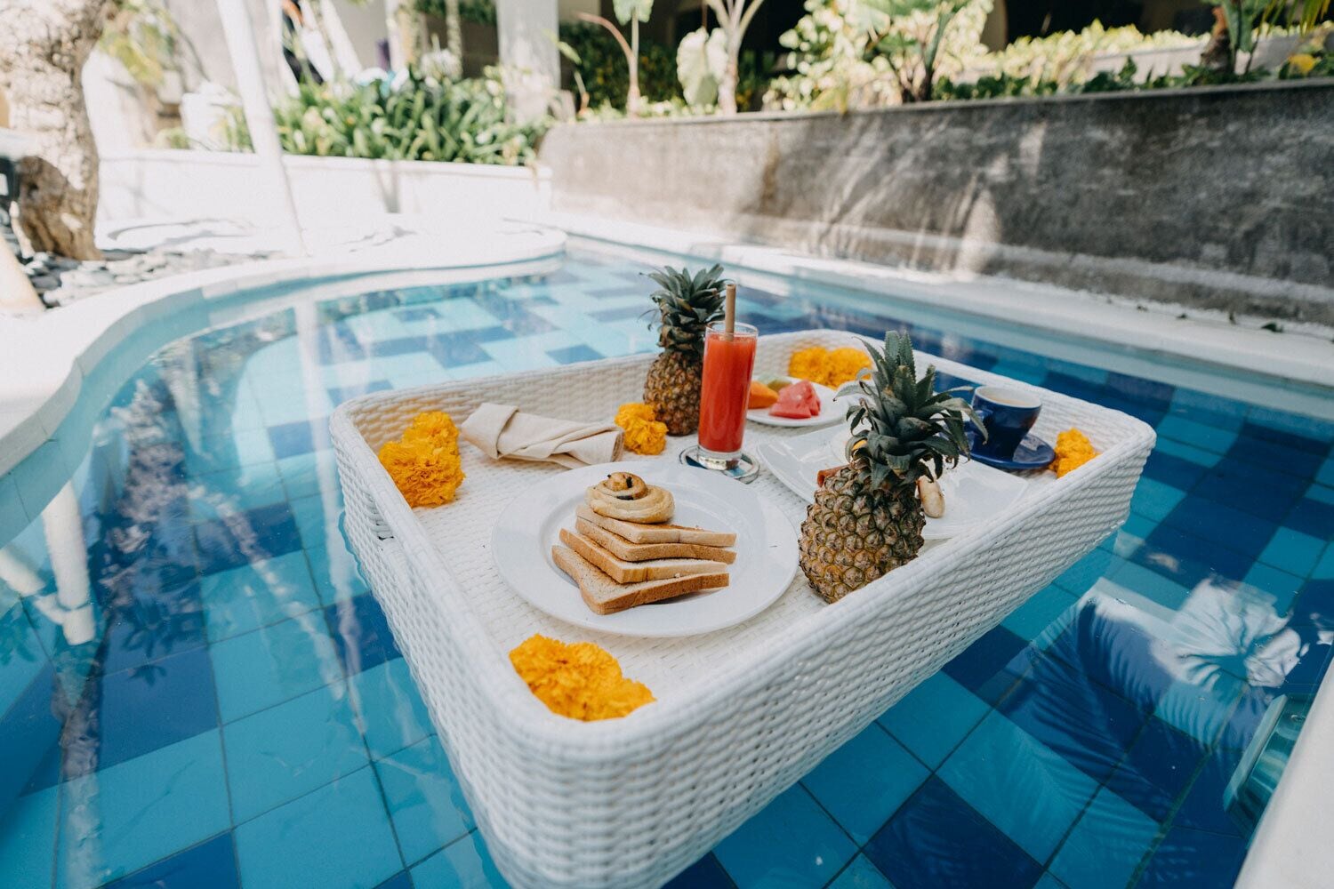 A poolside table with food and drinks.