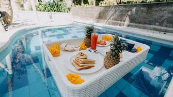 A poolside table with food and drinks.