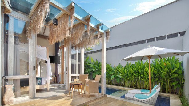 A modern outdoor area with a pool, lounge chairs, and a dining table. - 18 Suite Villa Kuta (Kuta)