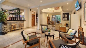A spacious lobby with a bar area, seating arrangements, and a television mounted on the wall. - 18 Suite Villa Kuta (Kuta)