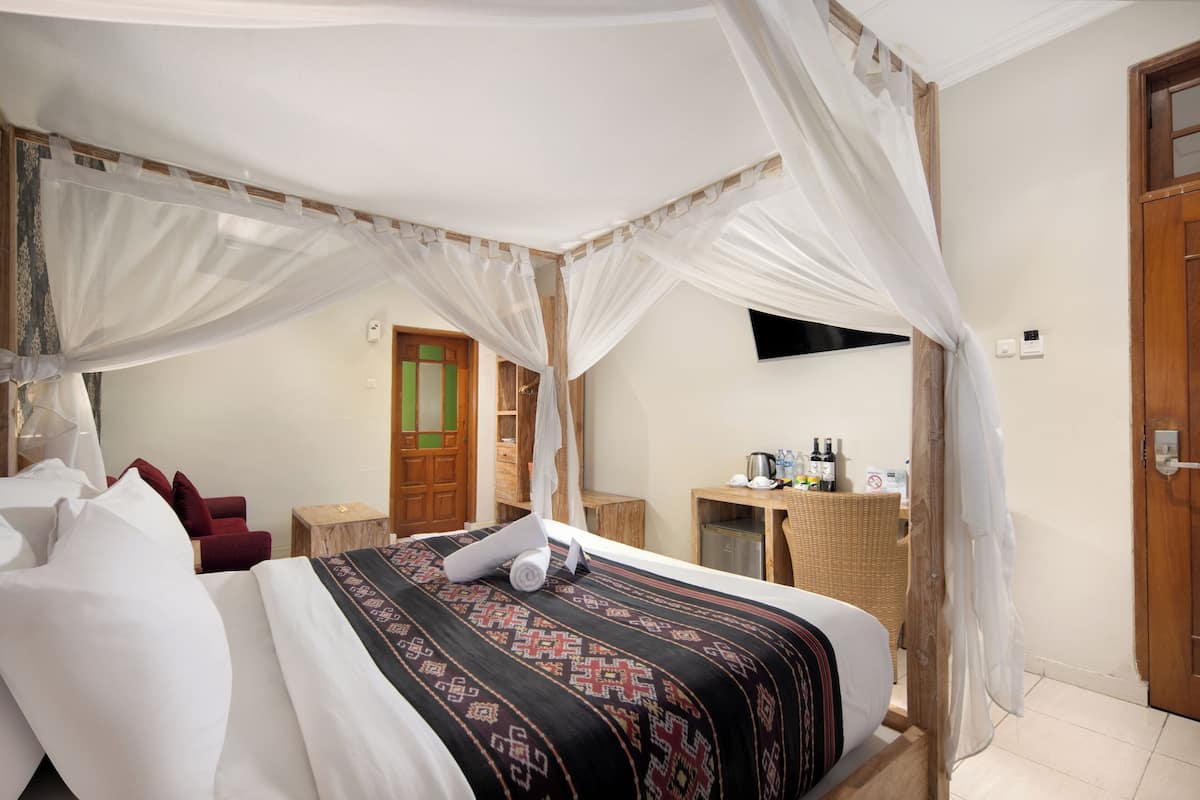 Deluxe kamer | Luxe beddengoed, een minibar, een kluis op de kamer, een bureau
