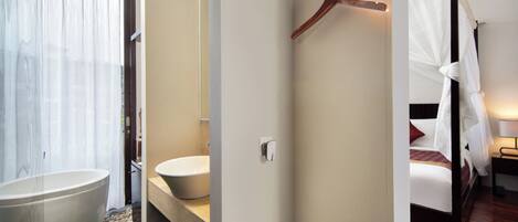 A modern bathroom with a freestanding bathtub, a sink, and a shower area.
