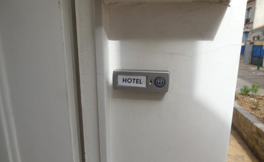 A hotel door with a sign labeled "HOTEL" and a keyhole.