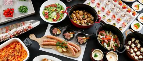 A variety of dishes including pasta, salads, and appetizers spread out on a table.