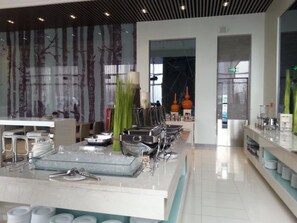 A modern restaurant with a long counter, glassware, and neatly stacked plates. - Holiday Inn Express Beijing Yizhuang by IHG (Beijing)