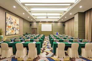 A conference room with rows of tables, chairs, and a projector screen. - Holiday Inn Express Beijing Yizhuang by IHG (Beijing)