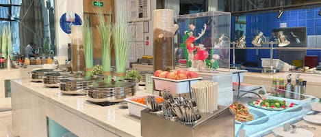 A buffet area with various food items and utensils.
