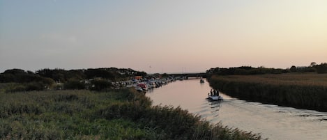 Un río con barcos y un puente al fondo.