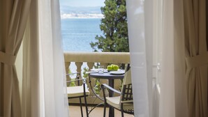 Varanda com uma mesa posta para dois, com vista para a costa.