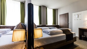 A hotel room with two beds, a desk, a wardrobe, and a window with curtains. - RiKu HOTEL Neu-Ulm (Neu-Ulm)