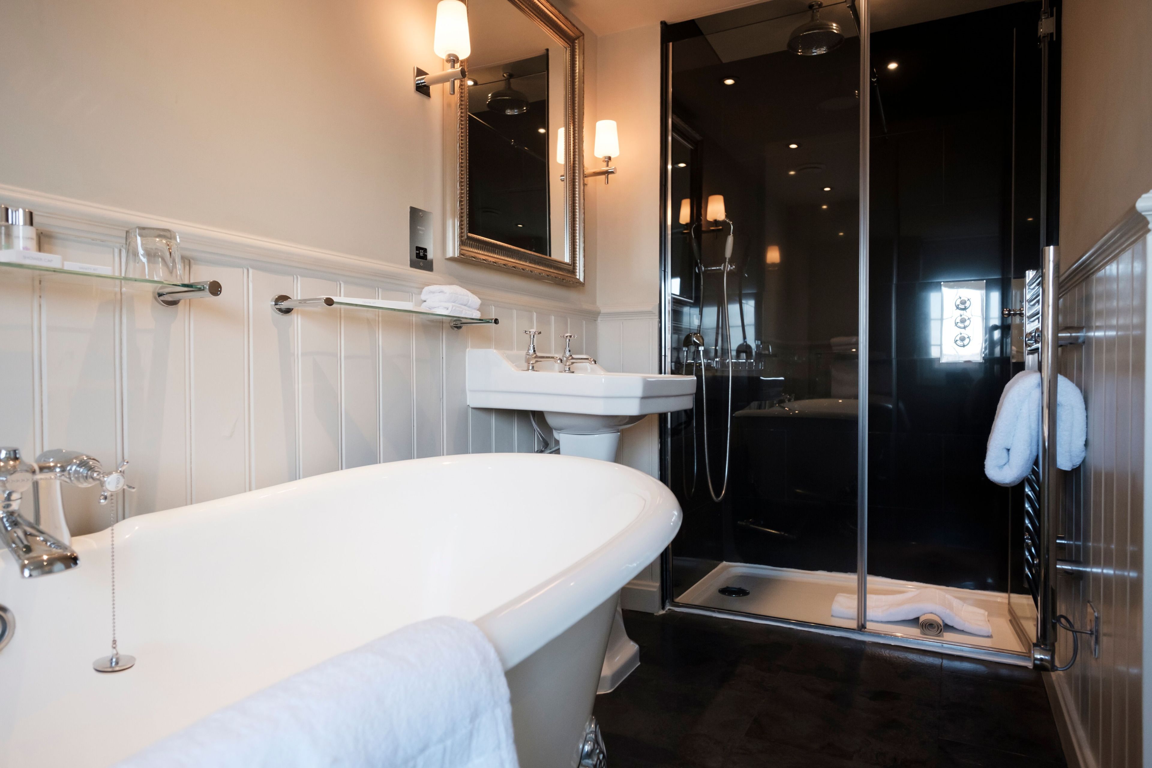 A modern bathroom with a freestanding bathtub, a glass-enclosed shower, and a white sink.