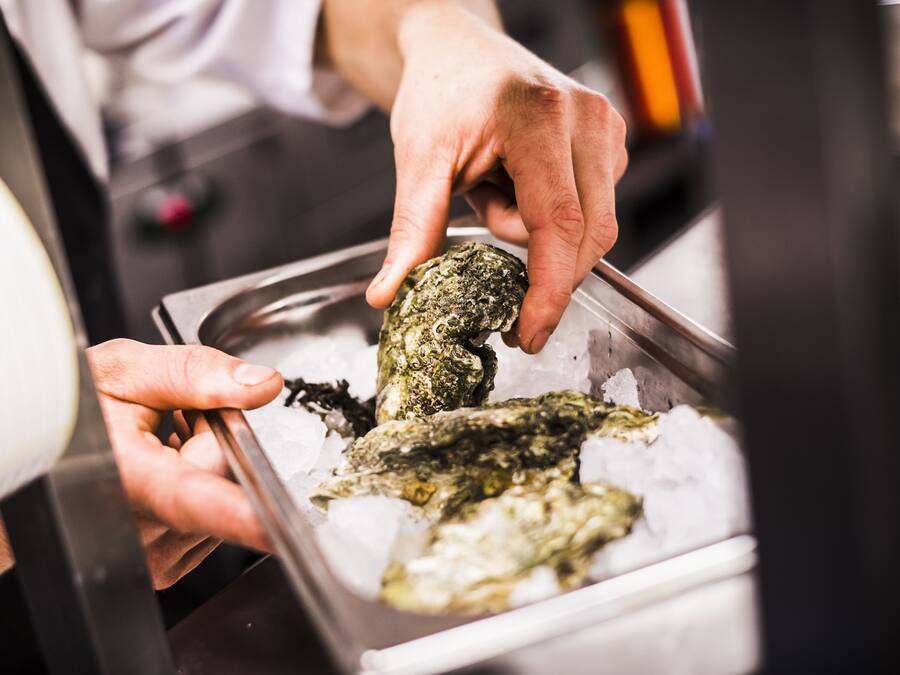 A person handling seafood on ice.