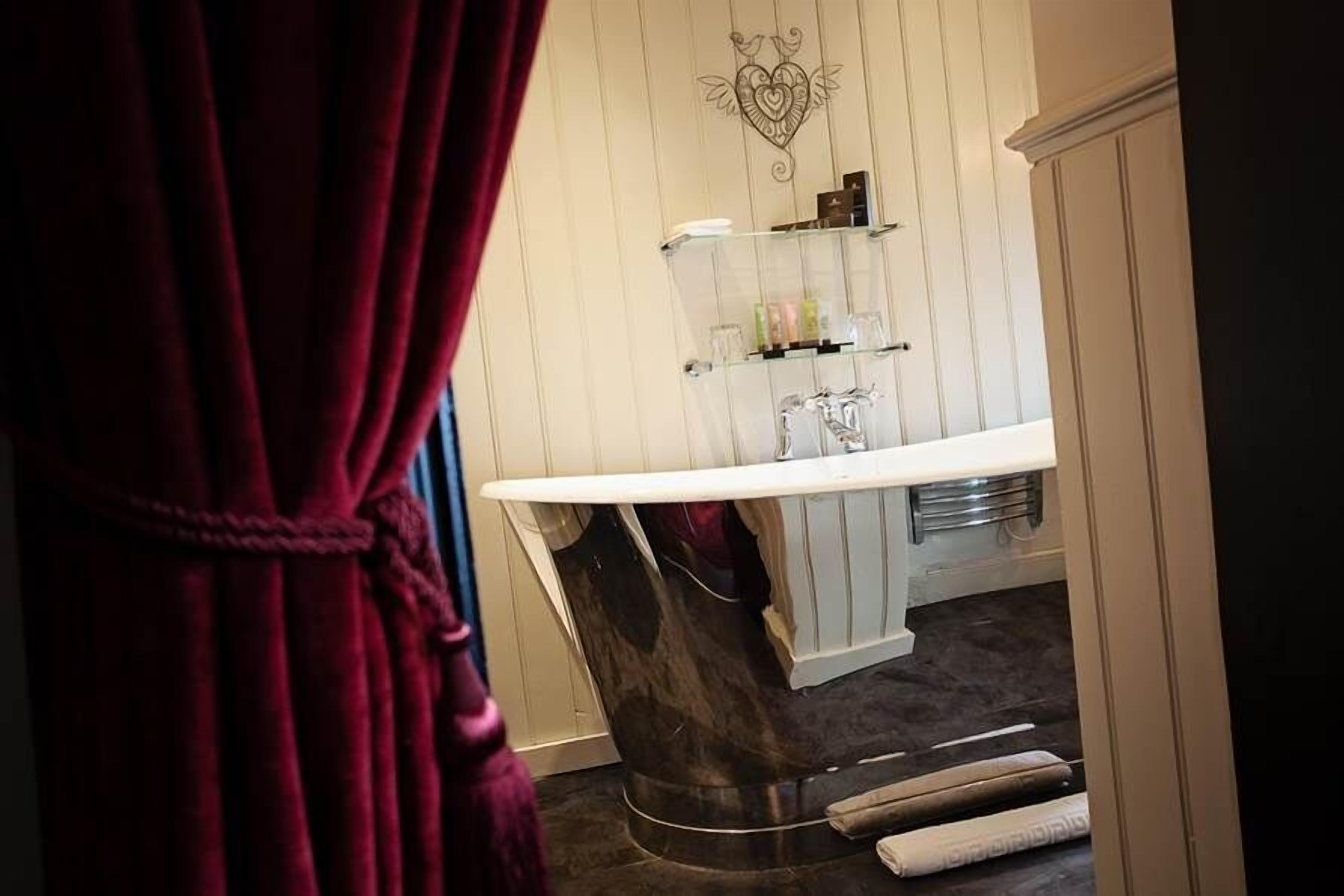 A bathroom with a marble sink, glass shelves, and a decorative wall piece.