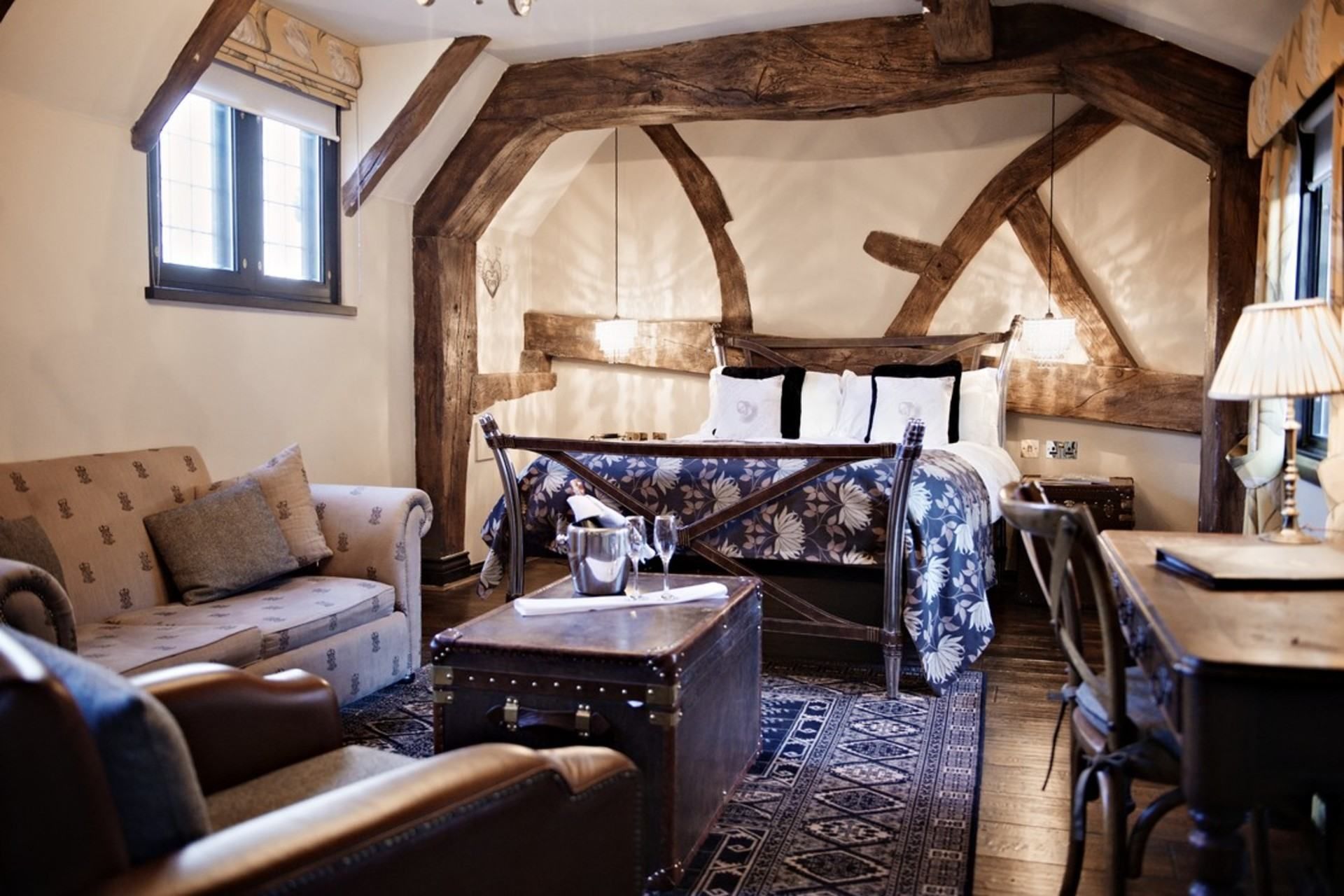 Ein gemütliches Zimmer mit Bett, Sofa, Tisch und Stuhl.
