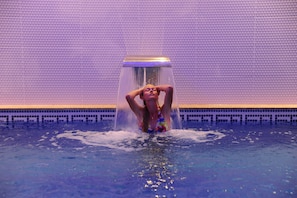 A person in a swimming pool with a water feature above them. - Blueberry Boutique Hotel - Boutique Class (Fethiye)