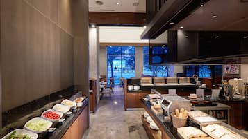 A buffet area with various food options, a seating area, and a view of the outdoors.