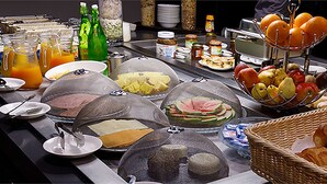 A buffet with various food items and beverages, including fruits, pastries, and condiments. - Tulip Inn Sainte Clotilde La Reunion (Saint-Denis)