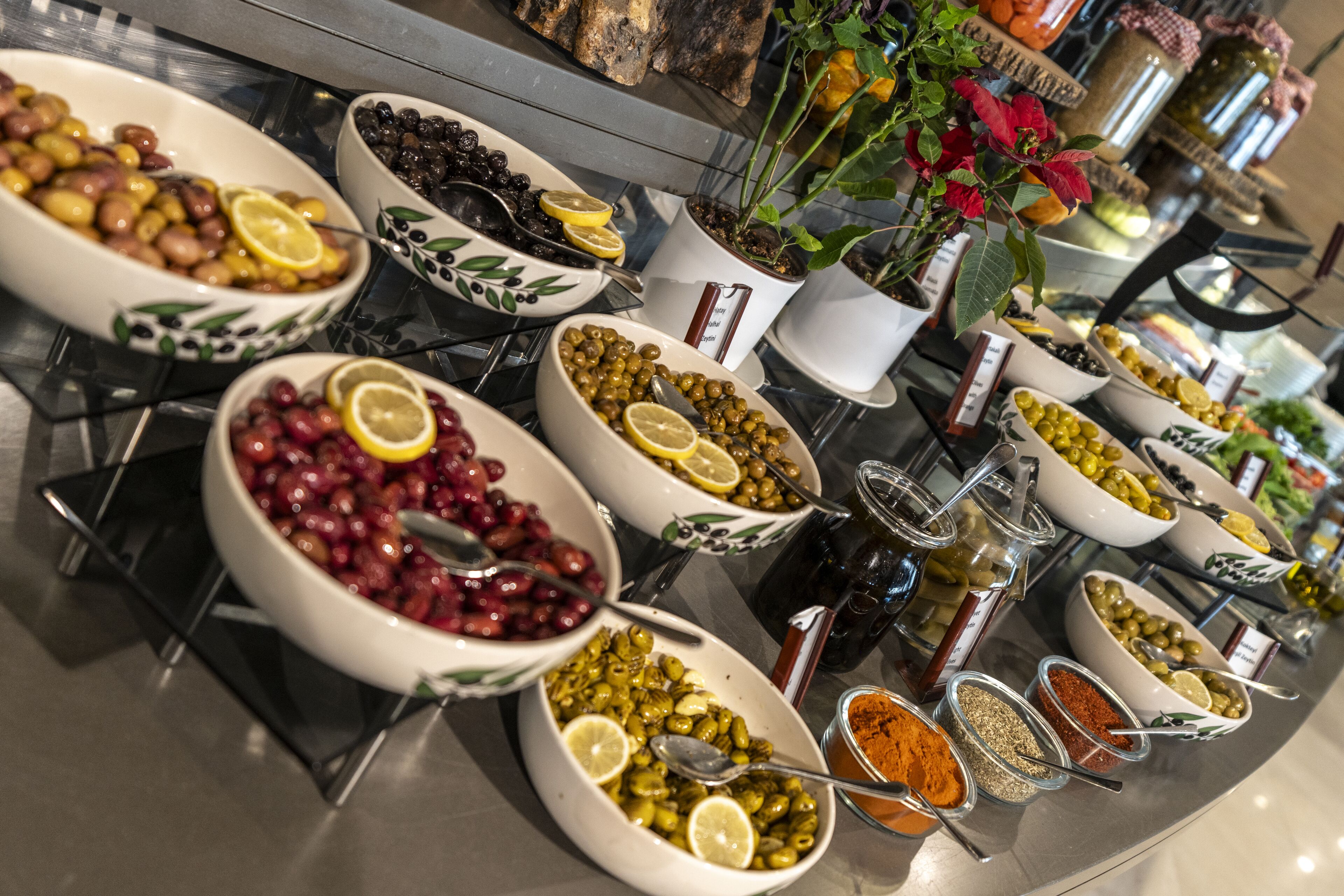 A buffet with various food items including olives, lemons, and spices.