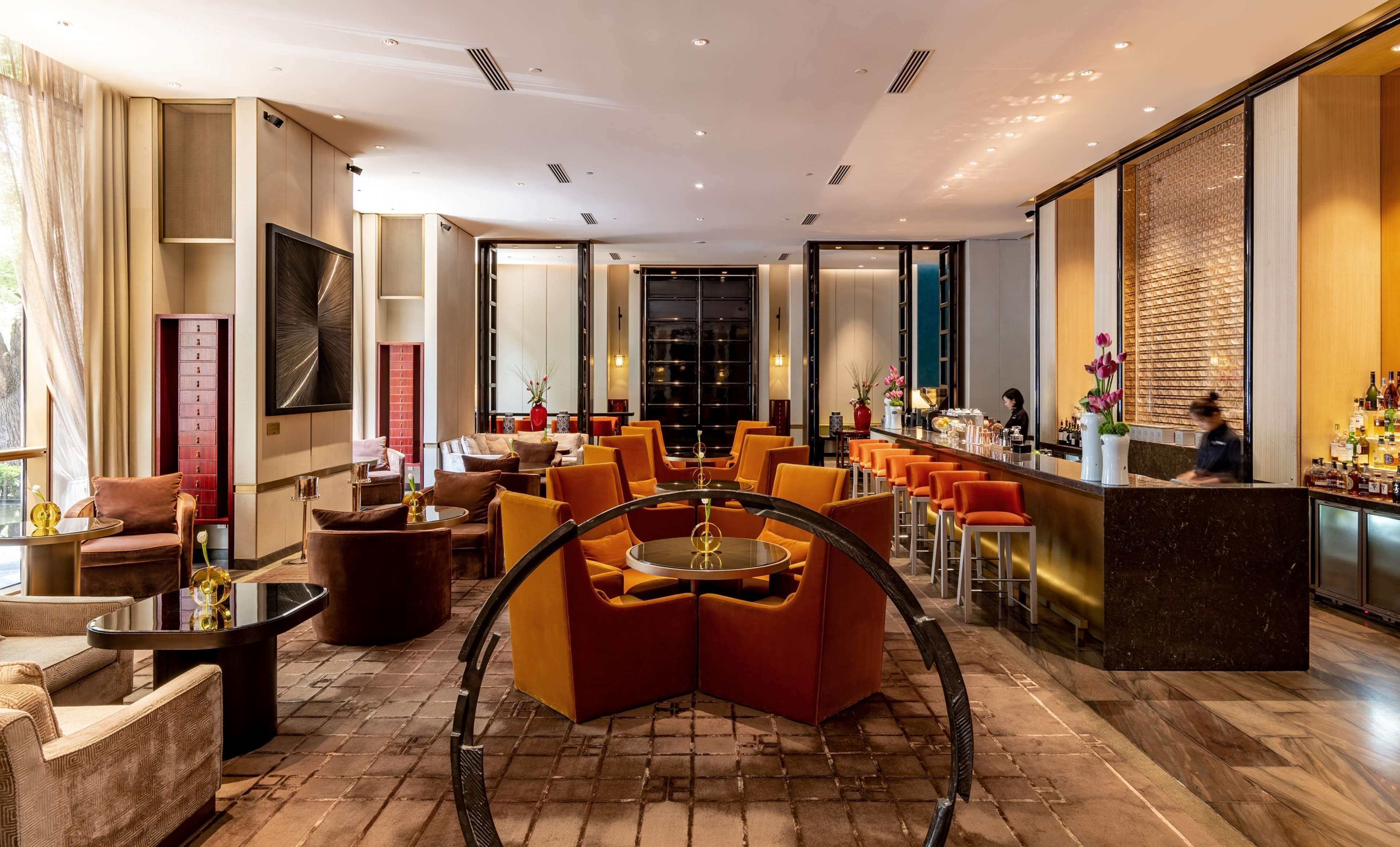 Ein moderner Lounge-Bereich mit Sitzgelegenheiten, einer Bar und einem großen Fenster.