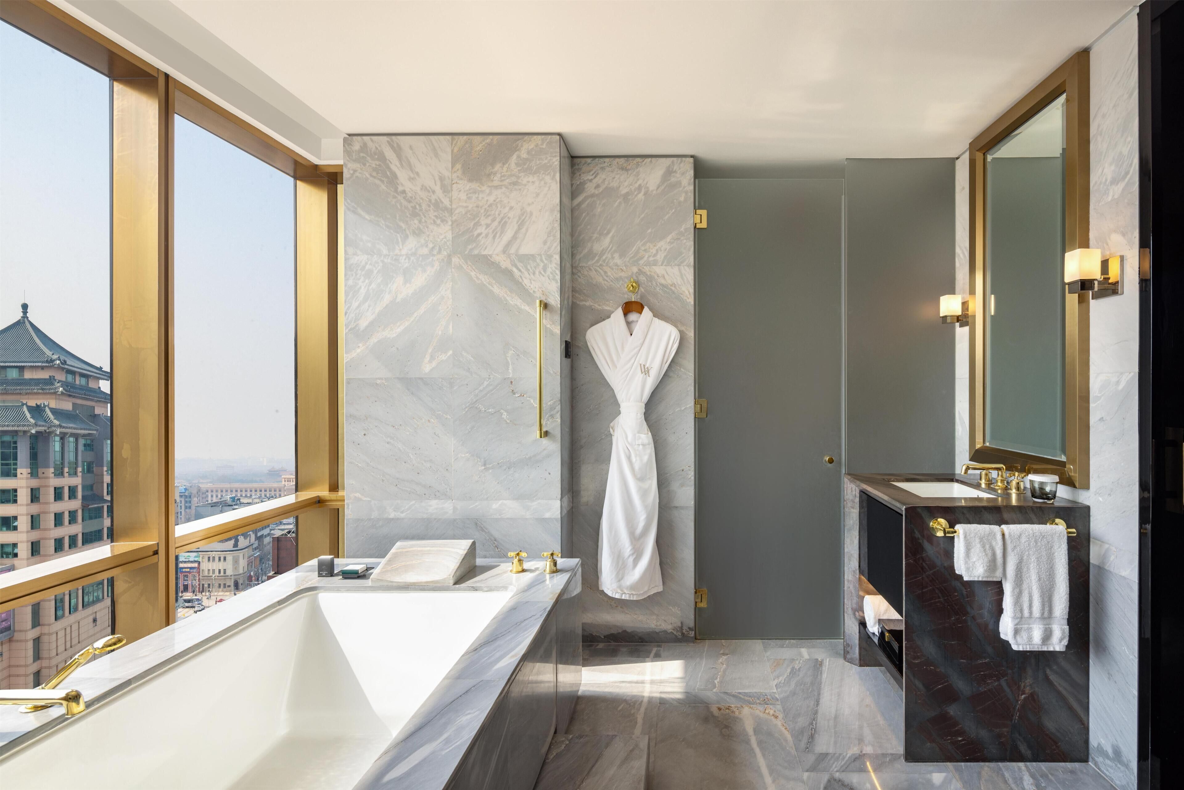 A modern bathroom with a bathtub, a shower, and a vanity with a mirror.
