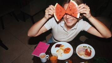 Una persona sentada a una mesa con platos de comida, una taza de té y un menú.