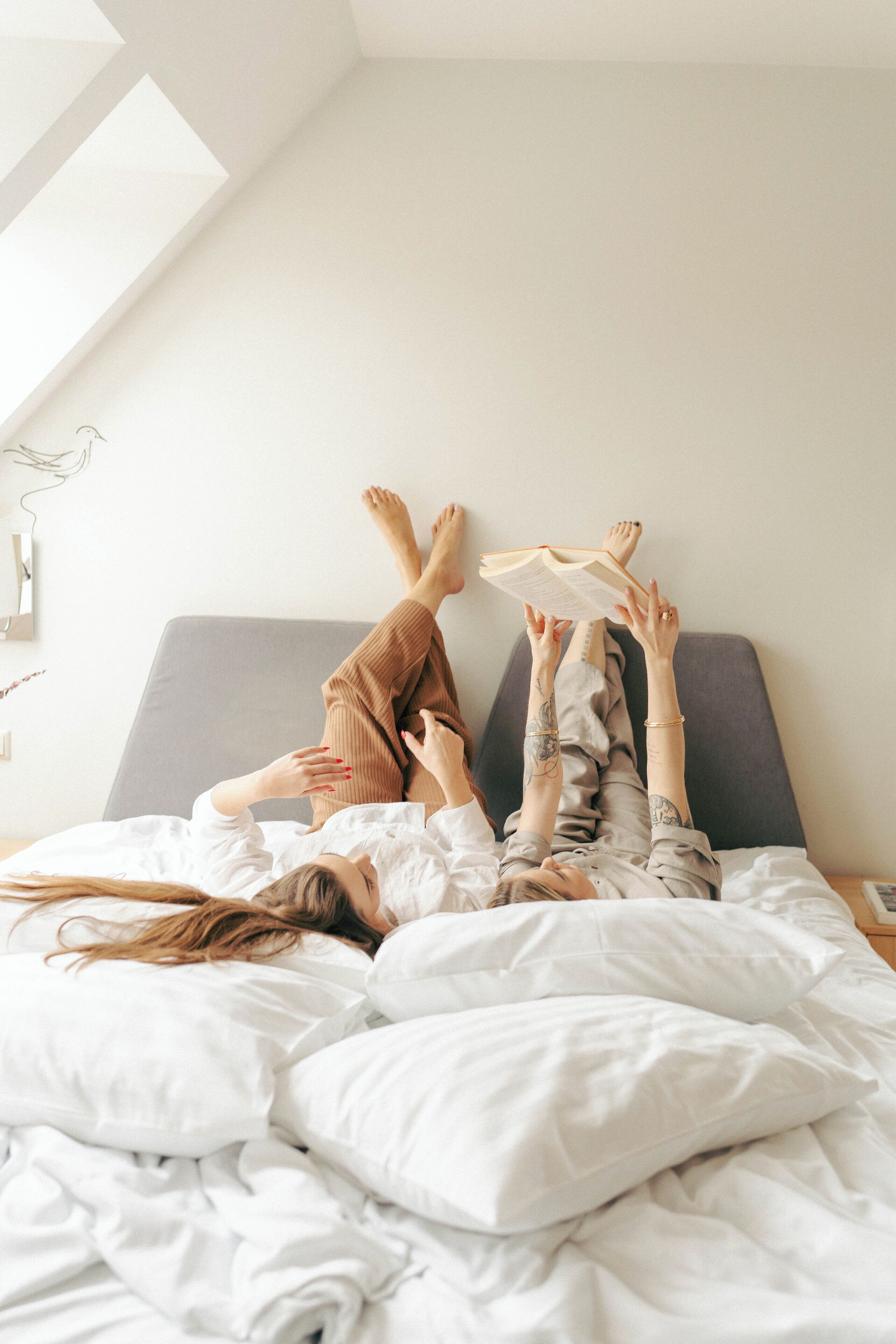 A bedroom with a bed, pillows, and a window.