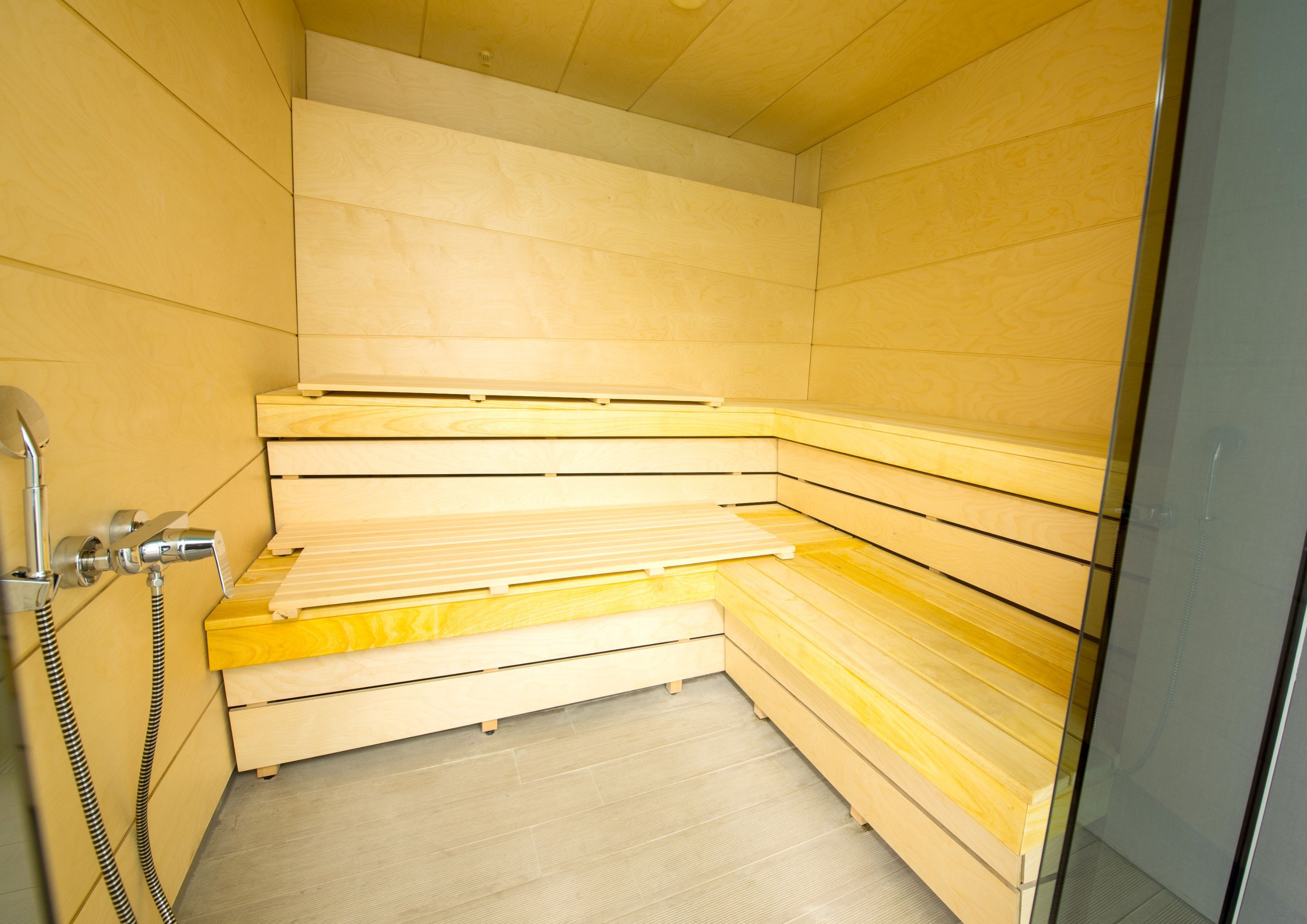 Uma sauna com bancos de madeira e área de chuveiro.