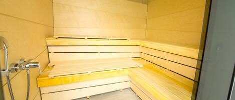 Uma sauna com bancos de madeira e área de chuveiro.