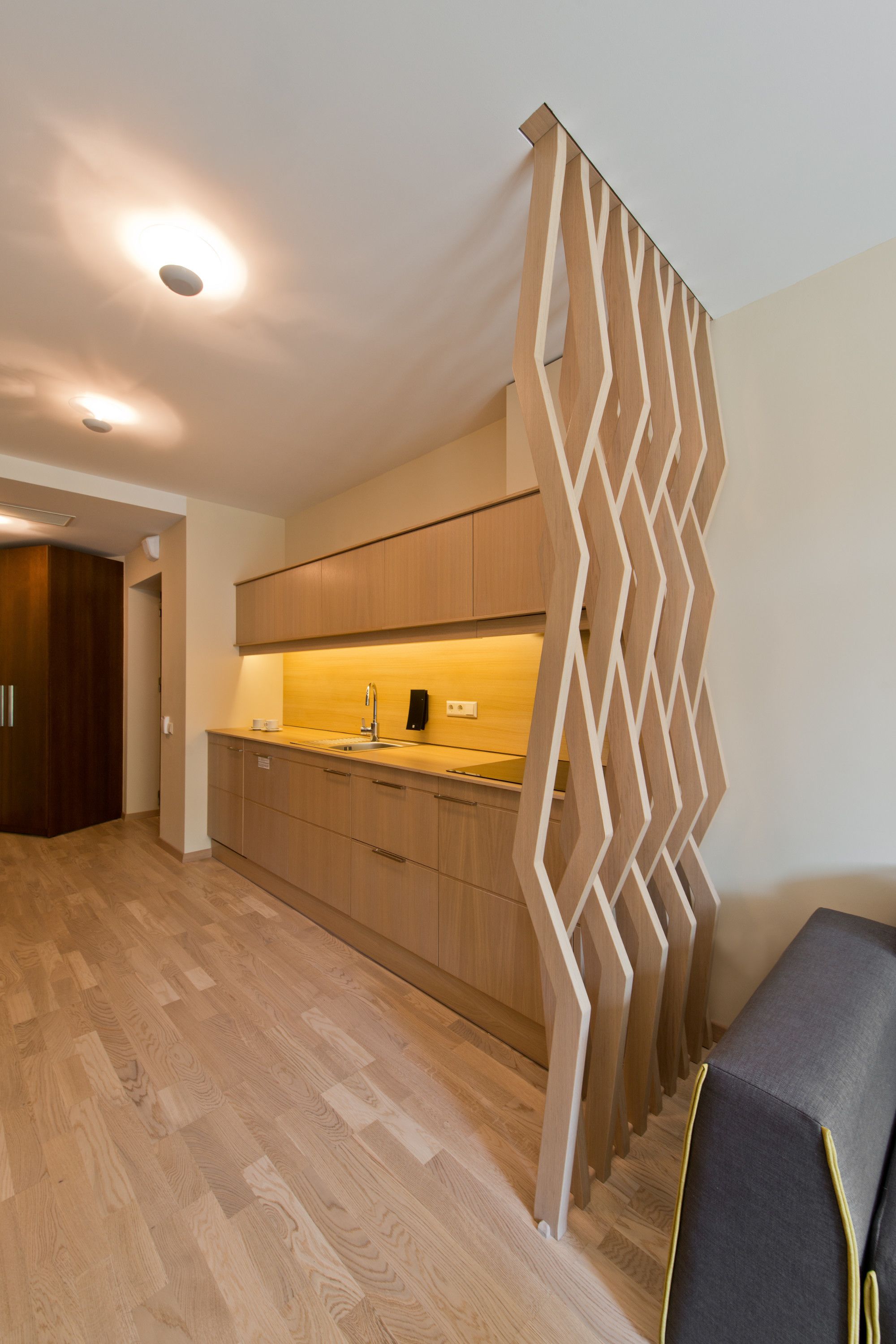 Una cucina moderna con mobili in legno, un'isola centrale e un pannello decorativo in legno.